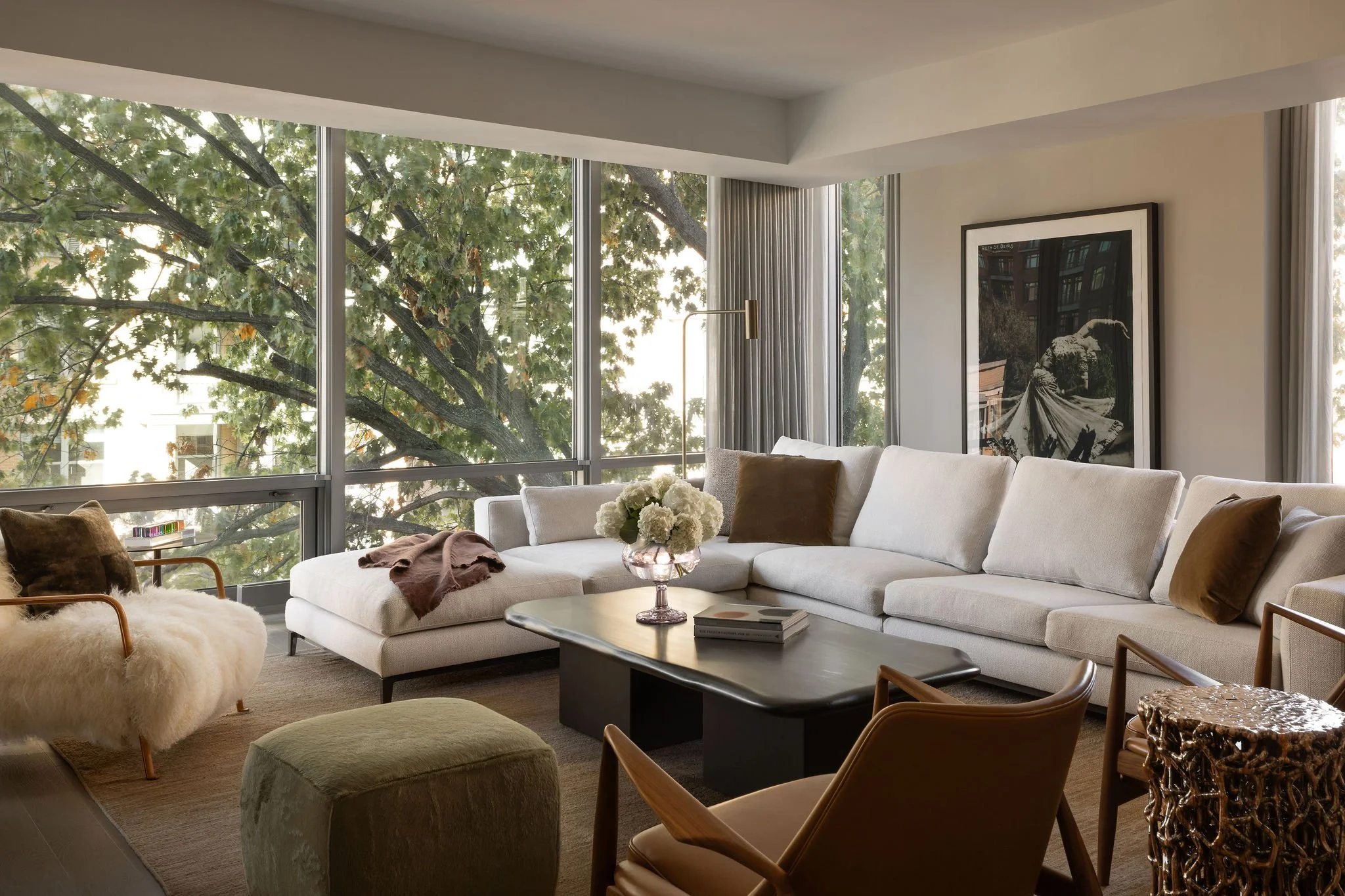 Georgetown condo living room featuring a Minotti sectional, custom ottoman, sculptural Seal armchairs, and a black-and-white photograph of Ruth St. Denis, layered in a nature-inspired palette that responds to the surrounding landscape.