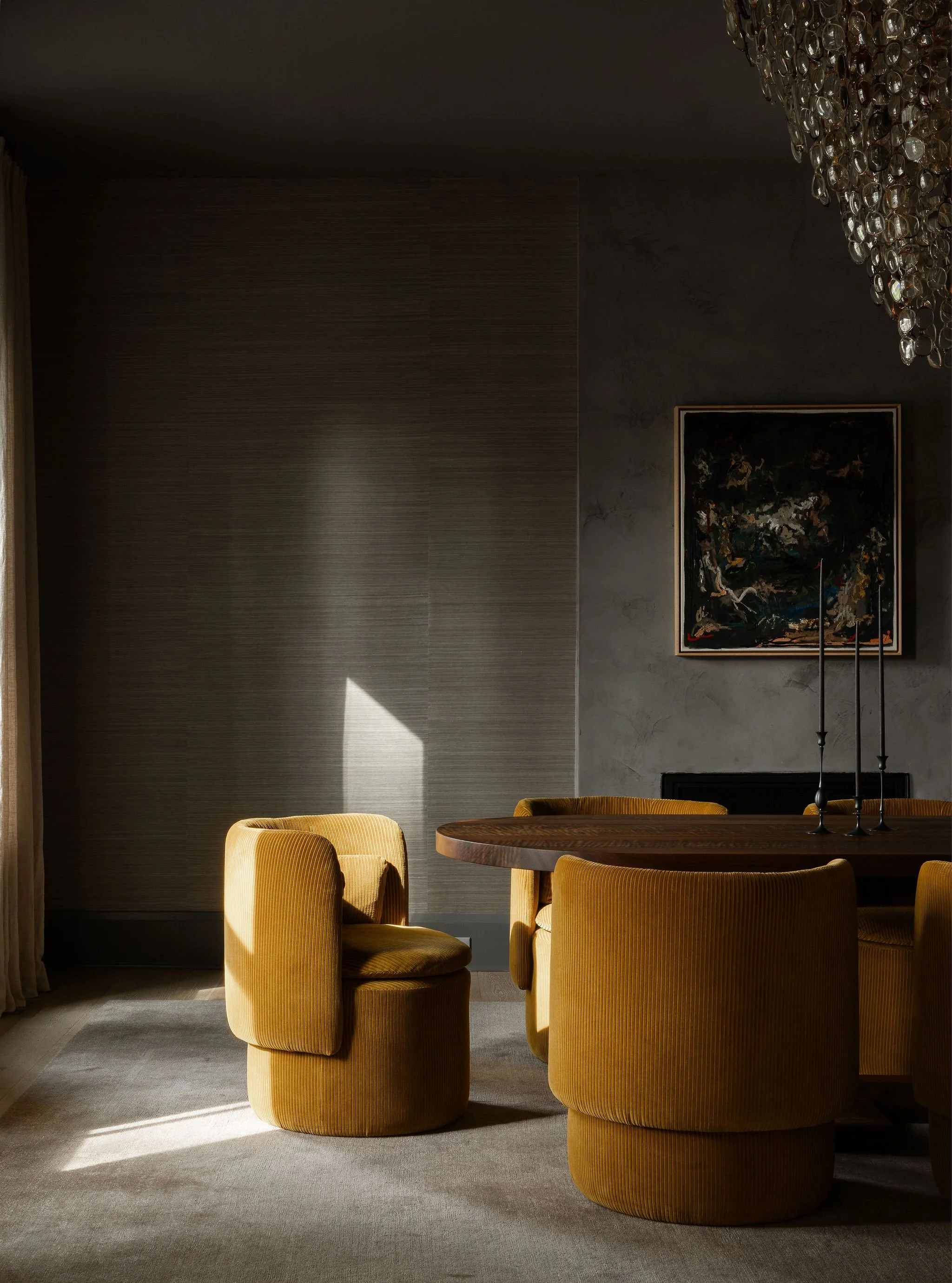 Moody dining room in a McLean, VA home with dark grasscloth walls, the Spectacle chandelier by Stuart Haygarth made from vintage eyeglasses, a commissioned abstract painting by Hue Thi Hoffmaster, a custom walnut dining table, upholstered chairs.